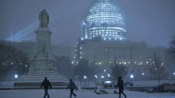 Светлините на Капитолия светеха през падащия сняг. Снимка: AFP